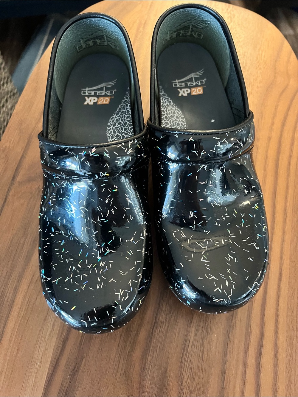 Dansko patent leather clogs in black with multicolor confetti.